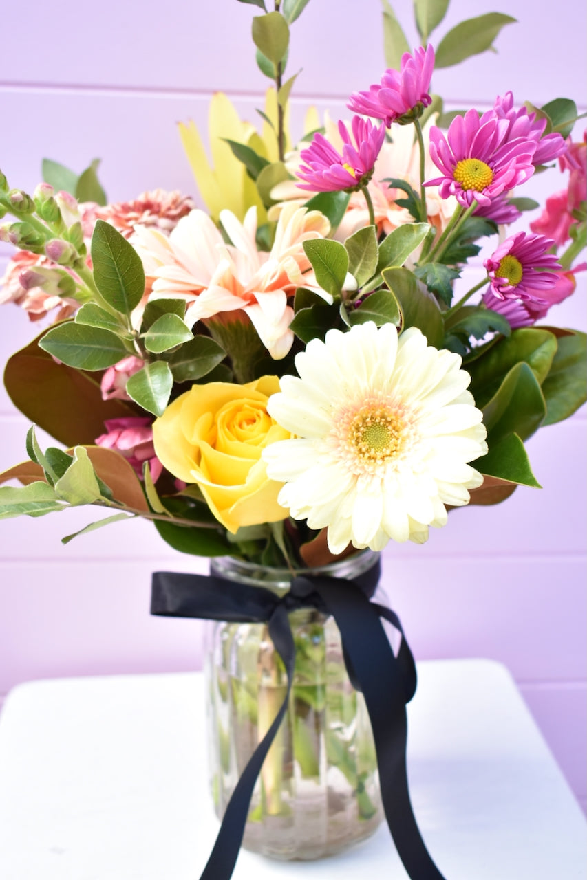 Glass jar with colourful flower bouquet