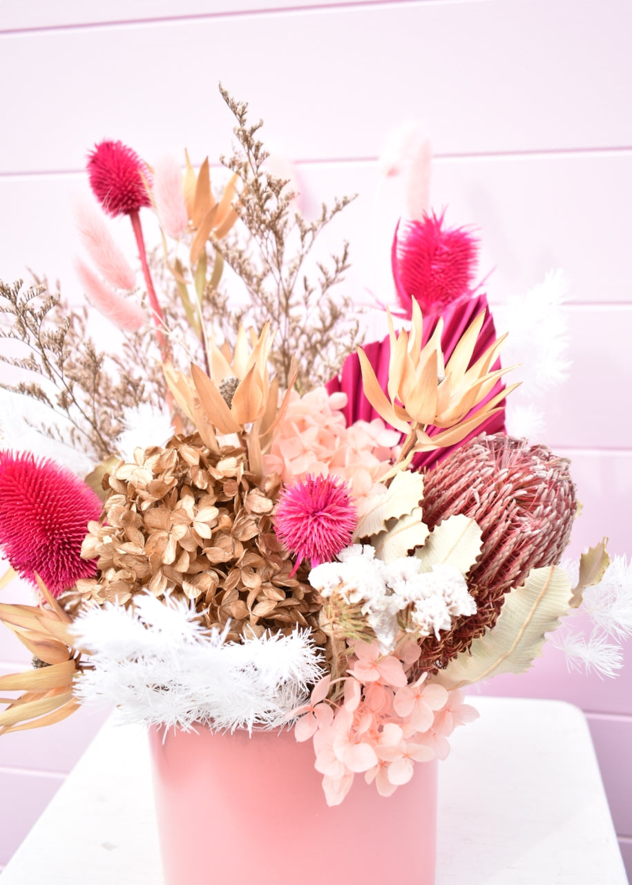 Dried flowers in pink, white and cream. Banksia and fern with hot pink palm