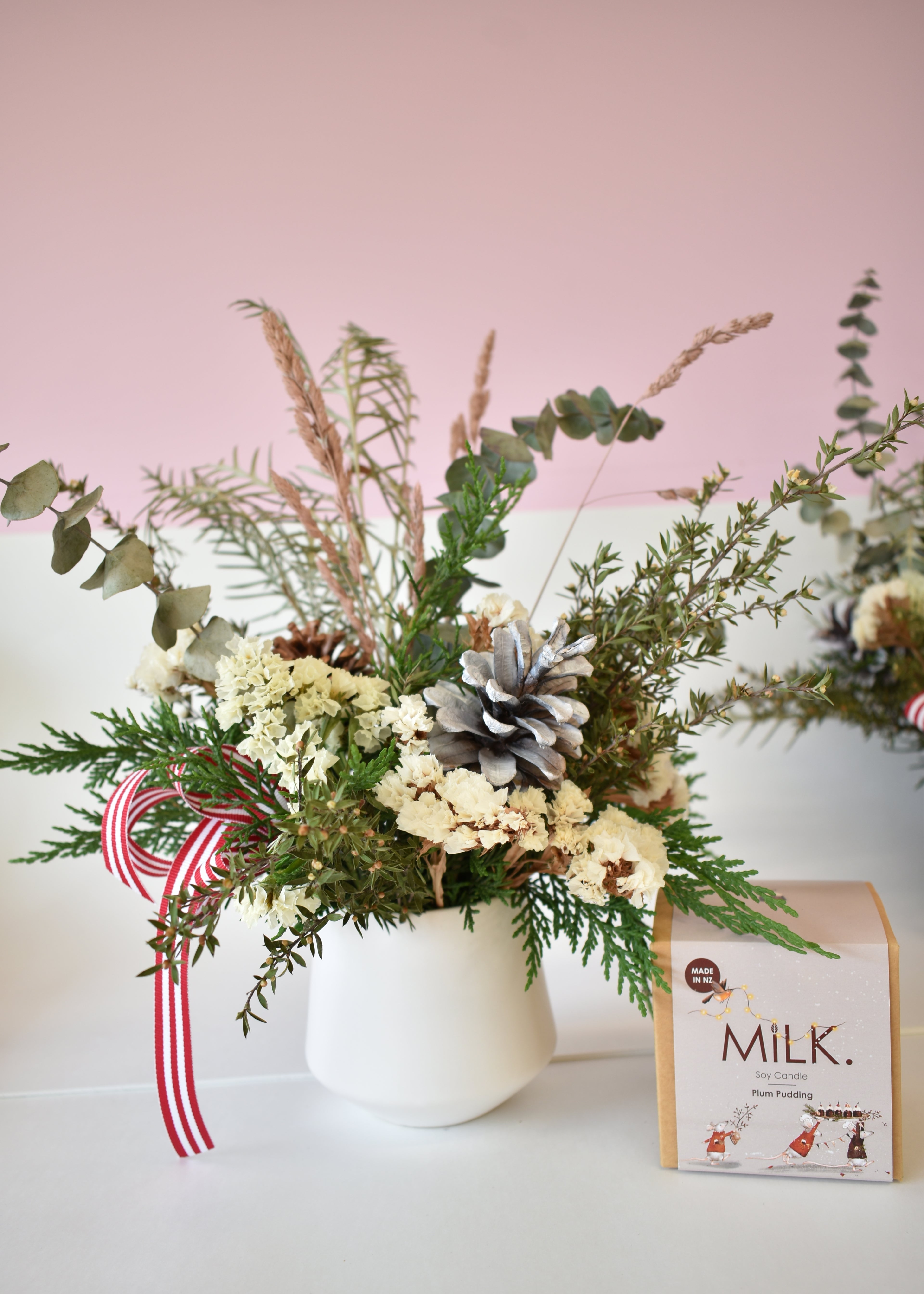 Festive everlasting dried flower arrangement with pinecones in white pot