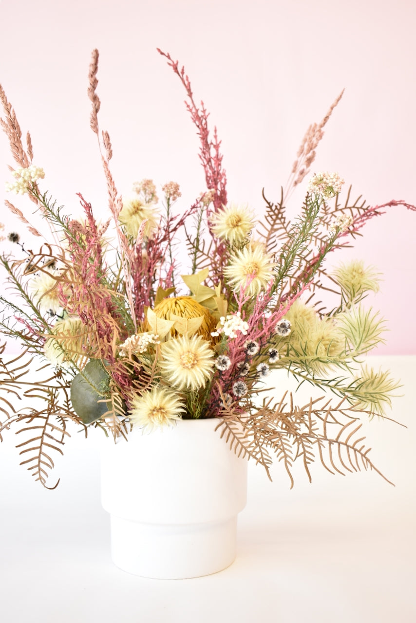Dried flowers in a white ceramic pot