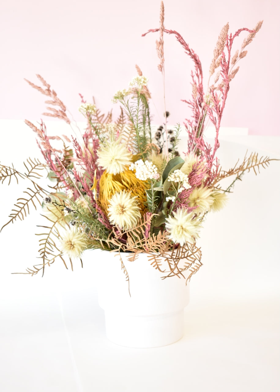 Dried flowers in a white ceramic pot