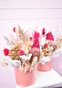 Dried flowers in pink, white and cream. Banksia and fern with hot pink palm in a coral coloured pot
