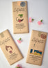 Three La Petite chocolate bars with different flavors on a white background with flowers.