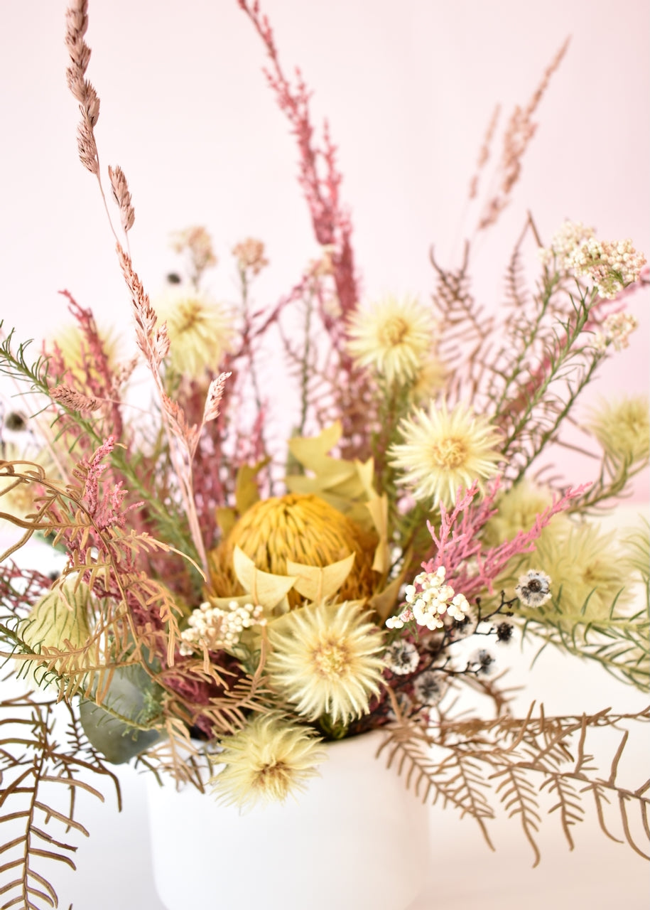 Dried flowers in a white ceramic pot