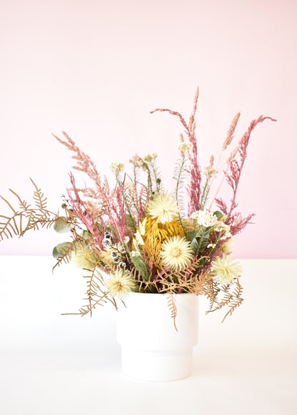 Dried flowers in a white ceramic pot