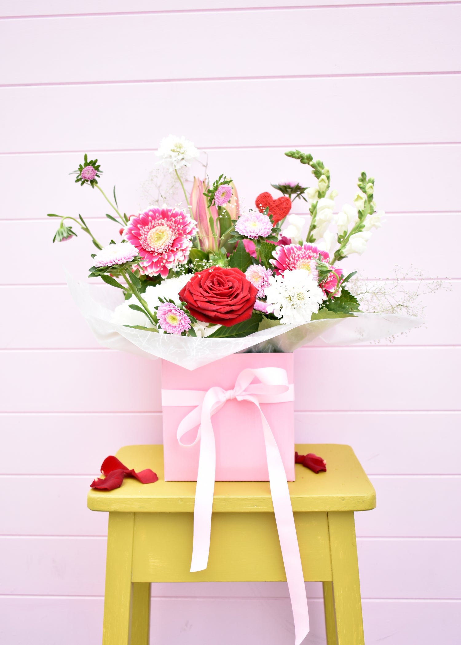 Fresh flowers in a pink box with pink ribbon. red roses, pink gerbera and white hydrangea. Valentine&