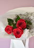 Bouquet of red roses with green leaves on a light pink background