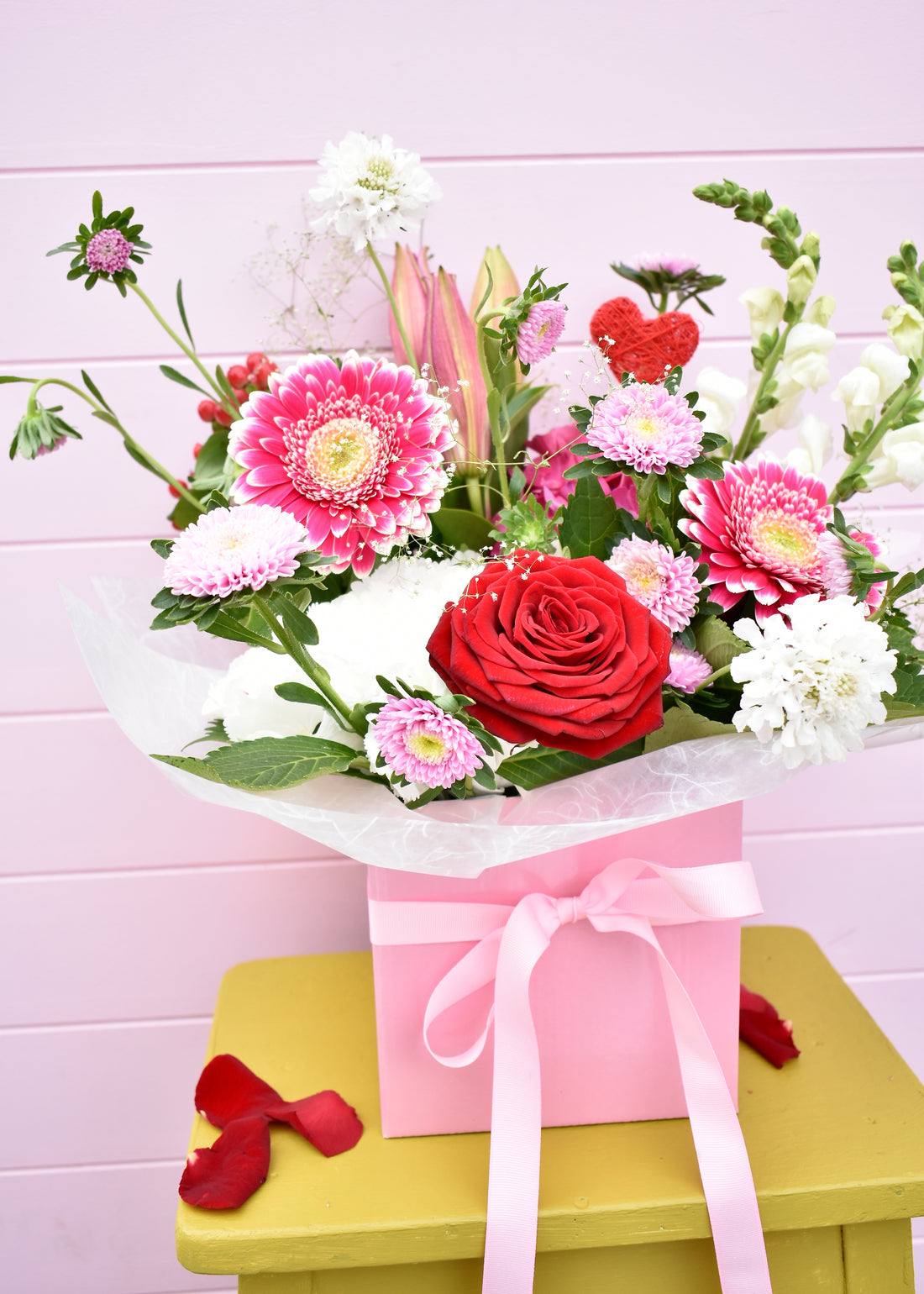 Fresh flowers in a pink box with pink ribbon. red roses, pink gerbera and white hydrangea. Valentine&