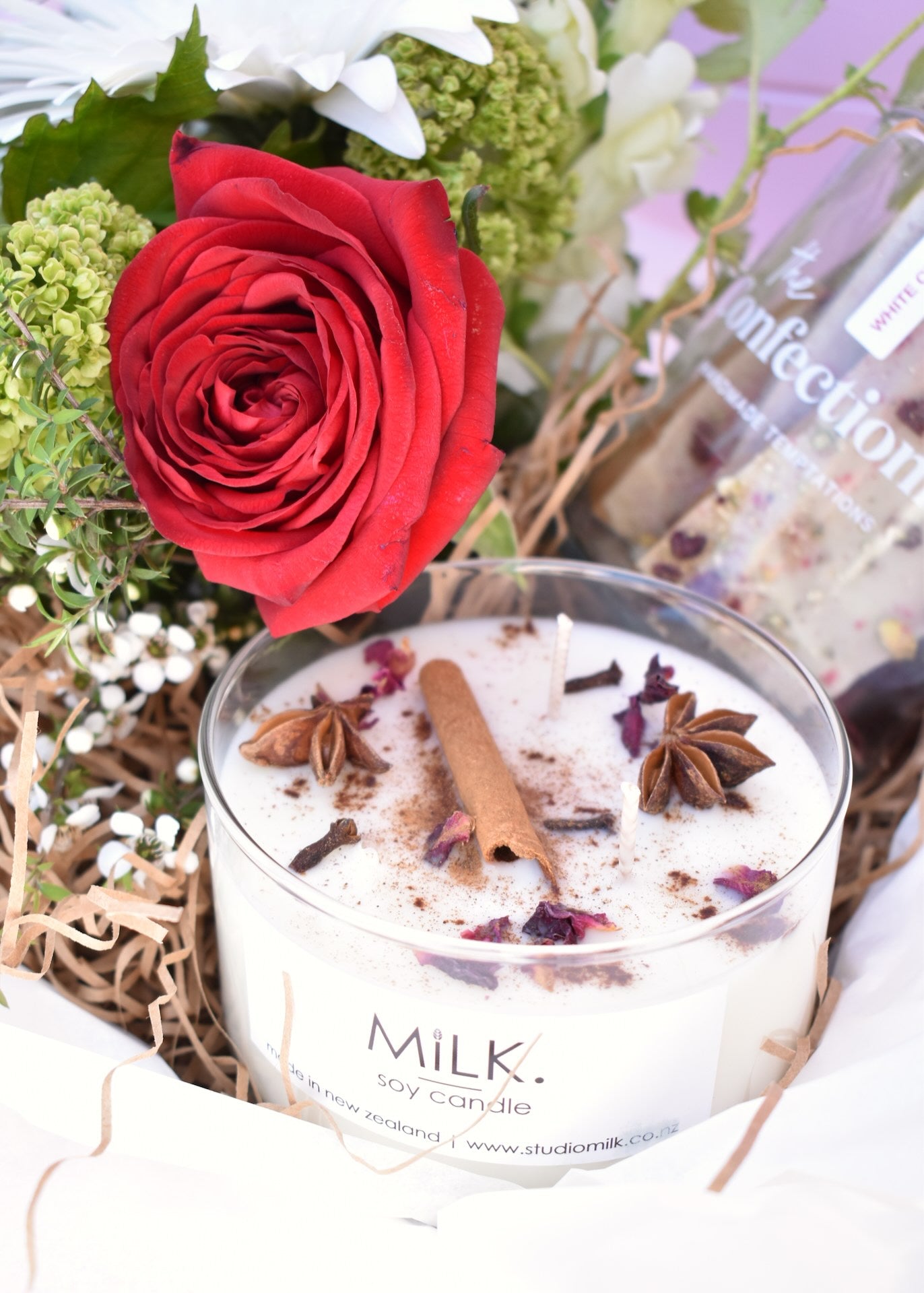 Christmas gift box with soy candle, fresh flowers and toffee