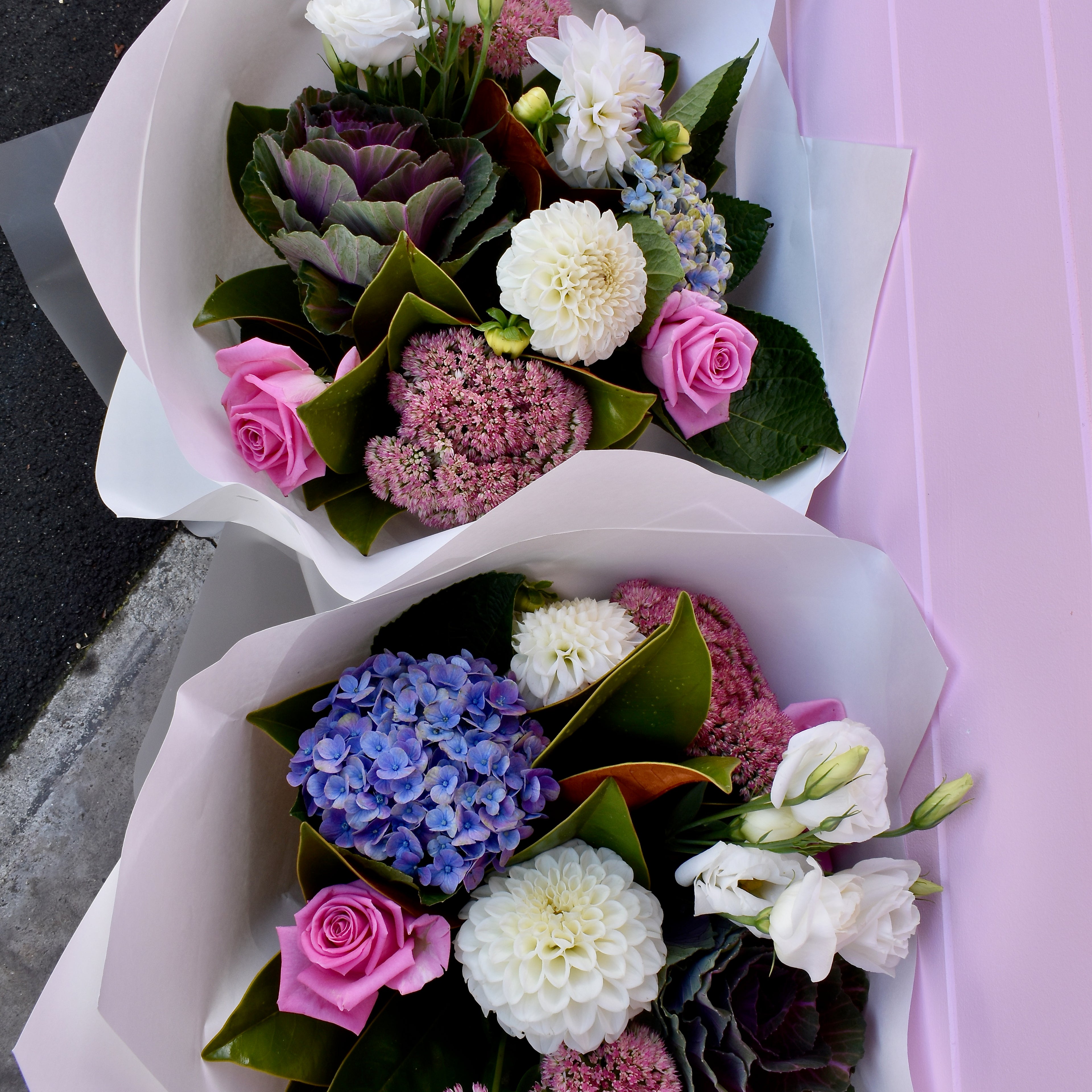 Two flower bouquets with pink roses and white paper