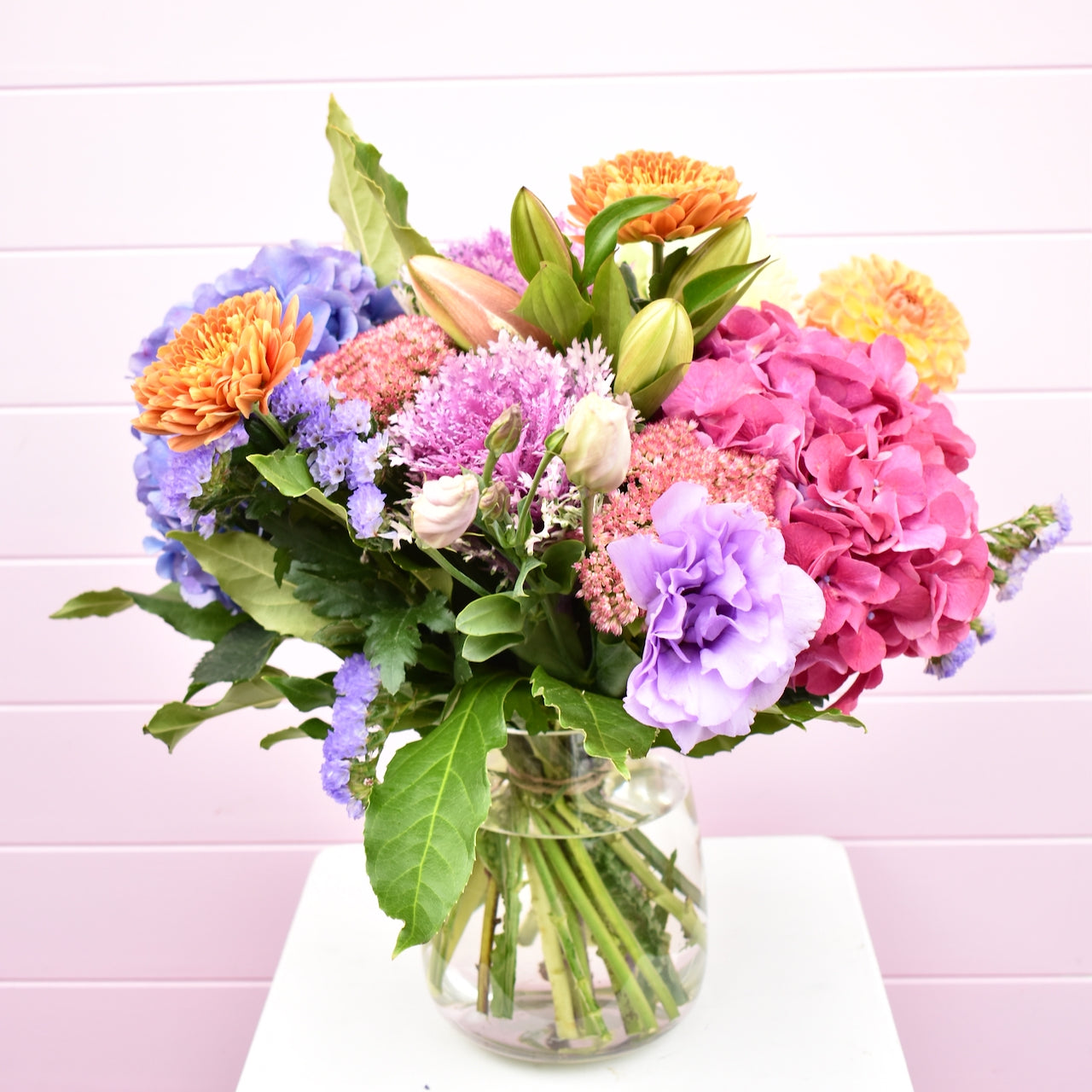Bright colourful flowers in glass vase. Pink, purple, orange fresh flowers