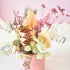 Dried flower arrangement in a pink ceramic pot. Colours of cream, white, peach and pink, designed by florist