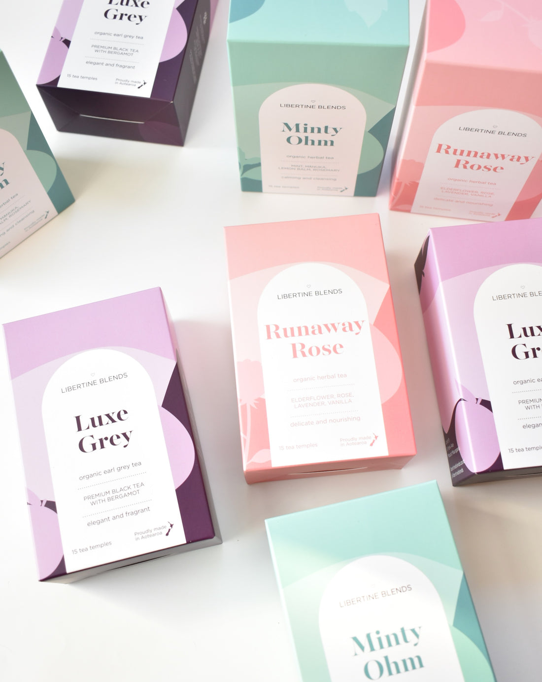 Boxes of herbal tea, mint, rose tea and earl grey in purple, pink and mint coloured packaging