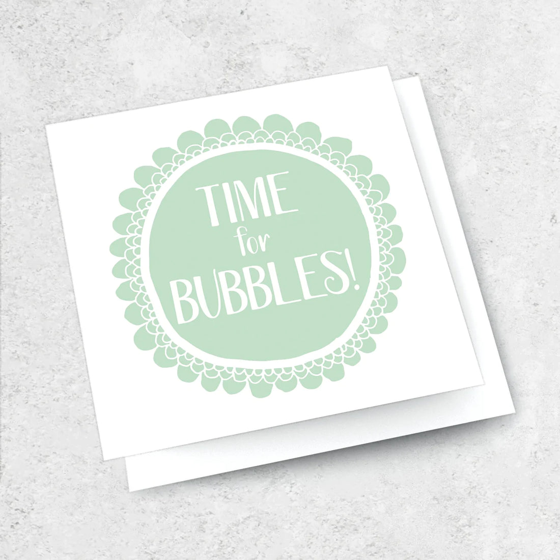 A white greeting card with a pale green hand painted circle on it. Text that reads &